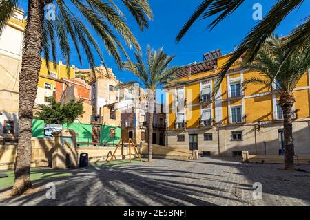 Vista sulla piccola piazza della città circondata da vecchie case colorate nella città vecchia di Alicante, Spagna. Foto Stock