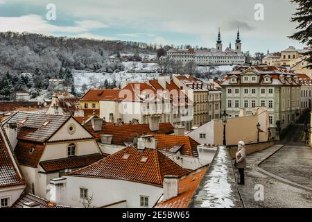 Praga, Repubblica Ceca - 8 gennaio 2021. Donna con maschera contro il covid19 coronavirus godendo la vista invernale di Praga, Europa. Adulti con maschera Foto Stock