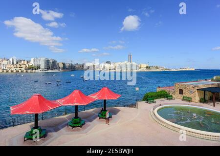 Popolare destinazione turistica Sliema lungomare che guarda attraverso Exiles Bay verso St Julian's Bay e St Julians Malta Foto Stock