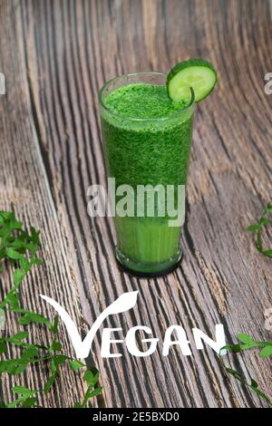 Sana frullato verde fresco o frullato con verdure verdi spinaci, avocado, mela su sfondo di legno texture con il testo vista dall'alto Vegan, copia Foto Stock