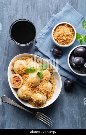 Gnocchi di prugne bolliti di fresco, conditi con pangrattato dolce tostato in una ciotola, serviti con succo di ribes nero Foto Stock