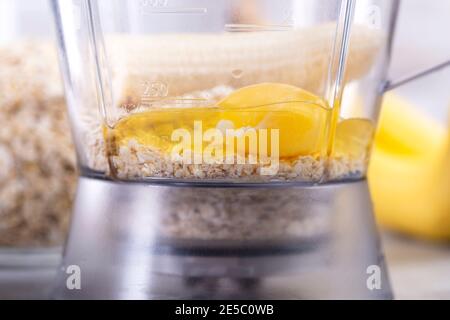 Avena e uova in un frullatore. Frittelle OAT con banana. Processo di cottura passo dopo passo. Banane, latte, uova, avena, sale. Foto Stock