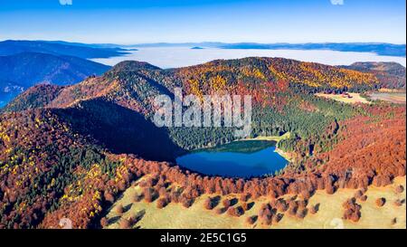 Lago di Sant'Ana, Transilvania, Romania. Splendido scenario autunnale con foresta colorata e idilliaco lago vulcanico, un popolare destinazione turistica e di viaggio