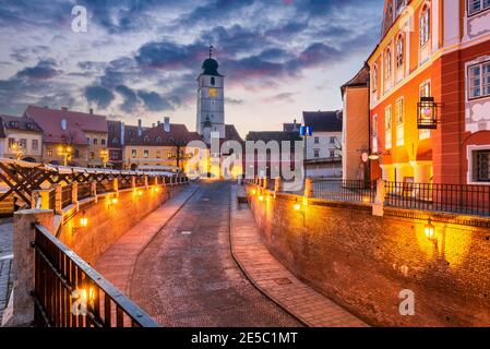 Sibiu, Romania - Lesser Square e Torre del Consiglio al crepuscolo. Transilvania città sassone. Foto Stock