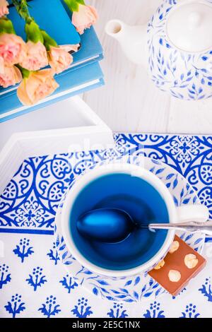Tazza di porcellana di tè organico blu farfalla pisello fiore e. cioccolato al latte con noci Foto Stock
