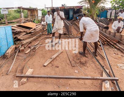 Nandakeshwar, Karnataka, India - 7 novembre 2013: Il gruppo di maschi misura le travi metalliche mentre stanno costruendo una più grande struttura metallica sotto il cielo d'argento su di Foto Stock