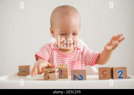 Bambina che gioca con cubetti di legno con numeri luminosi Foto Stock