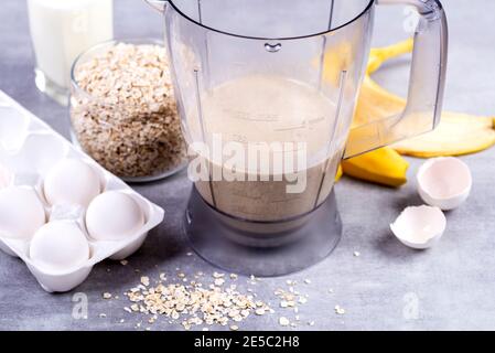 Avena e uova in un frullatore. Frittelle OAT con banana. Processo di cottura passo dopo passo. Banane, latte, uova, avena, sale Foto Stock