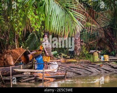 Kensi, Arguni, Indonesia - 06 febbraio 2018: Donna della tribù Mairasi che elabora la palma di sagu sulla riva del fiume. Bird's Head Peninsula, ovest Foto Stock