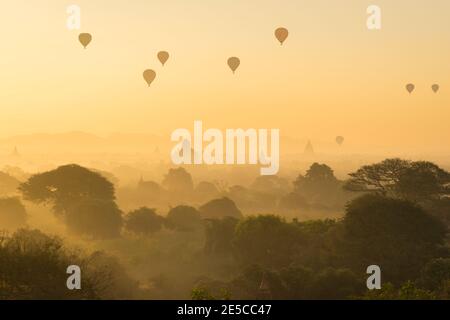 Antichi templi e mongolfiere all'alba nebbiosa, Bagan, ma Foto Stock