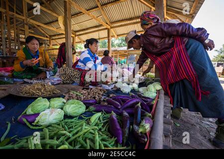 Donne che vendono verdure fresche sul mercato di strada in villaggio, lago Foto Stock