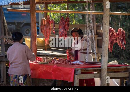 Uomo che vende carne sul mercato di strada in villaggio, lago Inle, Nyaungs Foto Stock