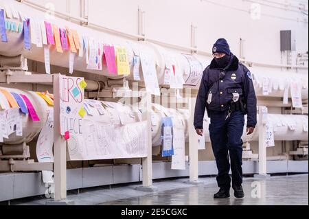 Un ufficiale della polizia del Campidoglio degli Stati Uniti cammina per i segni di gratitudine per il lavoro della polizia del Campidoglio degli Stati Uniti.i segni sono appesi nel tunnel che collega l'edificio dell'ufficio della casa di cannone al Campidoglio degli Stati Uniti. Foto Stock