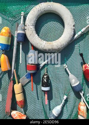 Salvavita, remi e boe da pesca appesi su una rete da pesca, Stati Uniti Foto Stock