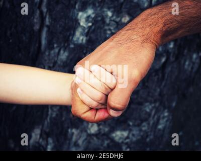 Primo piano di un uomo che tiene la mano di un bambino Foto Stock