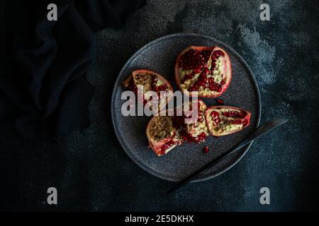 Semi di melograno organico su una piastra di pietra Foto Stock