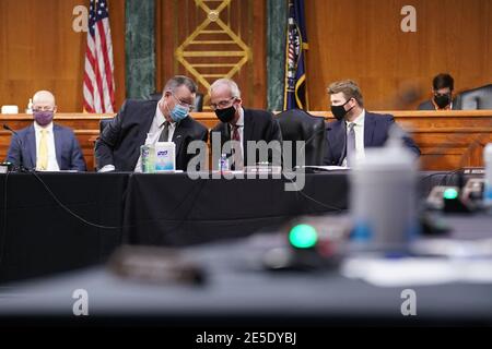 Il senatore degli Stati Uniti Jon Tester (democratico del Montana) e membro della commissione per gli affari dei veterani del Senato, seconda sinistra, E il presidente americano Senatore Jerry Moran (repubblicano del Kansas), un repubblicano del Kansas, indossare maschere protettive mentre si parla durante un'audizione di conferma per Denis McDonough, segretario degli Stati Uniti per gli affari dei veterani (VA) nominato per il presidente degli Stati Uniti Joe Biden, a Washington, DC, Stati Uniti, mercoledì 27 gennaio 2021. In qualità di capo di stato maggiore di Barack Obama, McDonough supervisionò la revisione del VA in risposta al suo scandalo del tempo di attesa del 2014 e in precedenza fungeva da sostituto della sicurezza nazionale Foto Stock