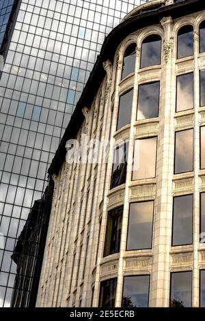 Primo piano con dettagli architettonici unici nell'edificio storico con una torre moderna sullo sfondo Foto Stock