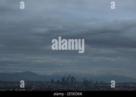 Los Angeles, California, Stati Uniti. 27 gennaio 2021. Le nubi della tempesta e le montagne innevate si trovano dietro lo skyline della città di Los Angeles mercoledì 27 gennaio 2021. Credit: Ringo Chiu/ZUMA Wire/Alamy Live News Foto Stock