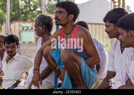 Siddanakolla, Karnataka, India - 7 novembre 2013: La democrazia al lavoro: Riunione del villaggio per risolvere la disputa degli agricoltori. Closeup di contadino in tessuto blu e rosso Foto Stock