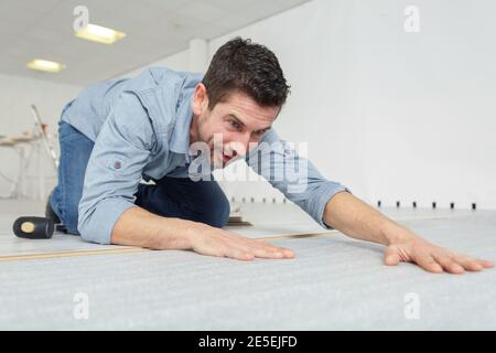 un operatore che taglia il nastro-misura del linoleum Foto Stock