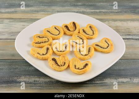 Biscotti olandesi al formaggio d'oliva nero su un piatto di spuntini bianco tabella Foto Stock