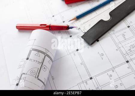 Rotoli di progetti di architettura e piani di case sul tavolo e gli strumenti di disegno architetto. Foto Stock