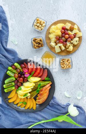 Antipasto e piatti di frutta, noci varie, miele, uva Foto Stock