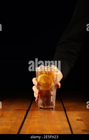 Bicchiere di tè lungo sull'isola per tenere a mano il ghiaccio Foto Stock