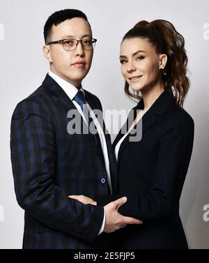 Giovane coppia uomo e donna in amore lavoratori d'ufficio partner i colleghi in tute ufficiali si aggirano a vicenda Foto Stock