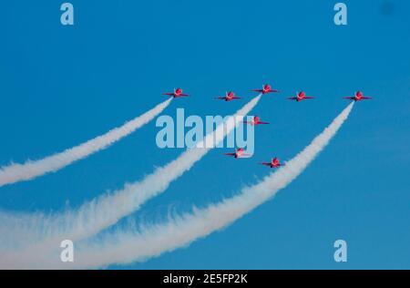 Le frecce rosse che volano via dal fumo bianco della macchina fotografica e. cielo blu chiaro Foto Stock