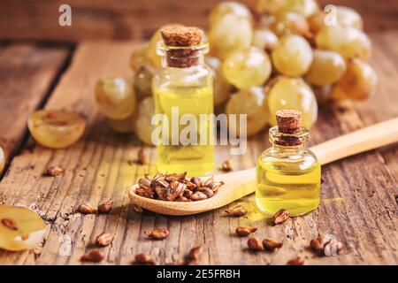 Olio di semi di uva in vaso di vetro su sfondo di legno. Focus.food selettivo Foto Stock