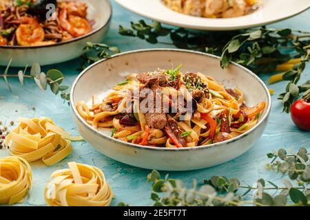 Primo piano su tagliatelle di udon fritte con carne di manzo Foto Stock
