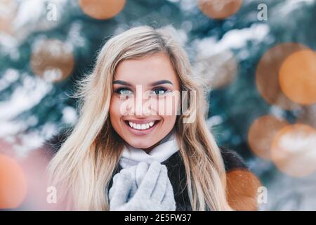 Natale Ritratto di giovane e bella ragazza in inverno foresta con luci bokeh di fondo Foto Stock