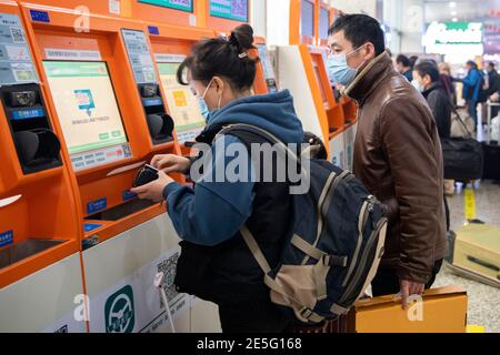 Changsha, la provincia di Hunan della Cina. 28 Gennaio 2021. I passeggeri che indossano maschere facciali acquistano i biglietti del treno su un distributore automatico self-service presso la stazione degli autobus di Changsha West a Changsha, nella provincia di Hunan della Cina centrale, il 28 gennaio 2021. La corsa di viaggio del Festival di Primavera, conosciuta come la più grande migrazione umana annuale del mondo, dura 40 giorni dal 28 gennaio all'8 marzo di quest'anno. Credit: Chen Sihan/Xinhua/Alamy Live News Foto Stock