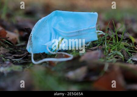 maschera medica, maschera quotidiana, usata maschera quotidiana gettata sulla strada Foto Stock