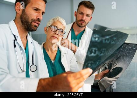 Gruppo di medici che osservano la scansione tc in ospedale per fare la diagnosi Foto Stock