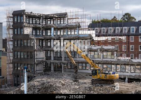 Demolition site high view (rubble, heavy machinery, excavator working & demolishing empty office building shell) - Hudson House, York, England, UK. Stock Photo