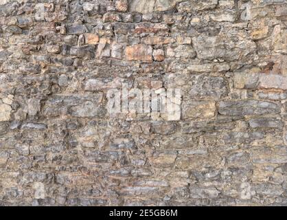 Vecchio muro grigio fatto di pietre naturali Foto Stock