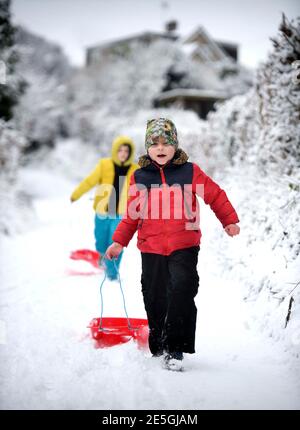 Due ragazzi si dirigono in slitta a Wotton-Under-Edge, Gloucestershire UK Foto Stock