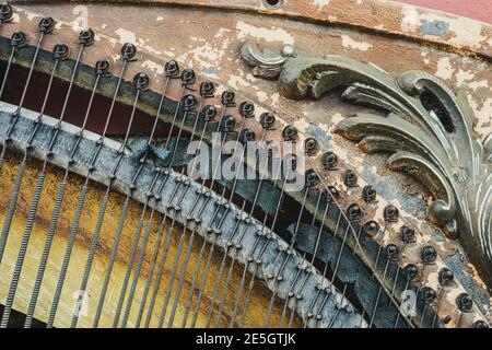 meccanica all'interno di un antico piano rotto eretto e intemperato, appoggiati a un muro di mattoni, primo piano foto Foto Stock