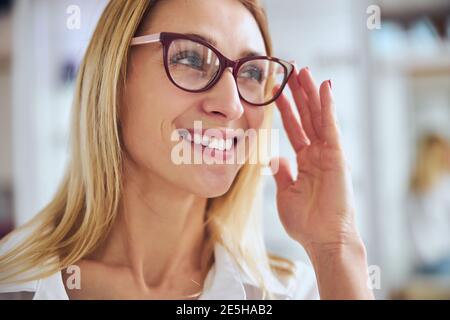 Donna d'affari che prova il set di vetro nell'ufficio di optometrist Foto Stock