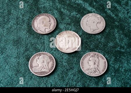 Lato opposto delle monete inglesi di argento sterling ( 92.5%) di metà Corona che variano da regina vittoriana, Edward VII & George V Foto Stock