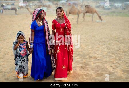 Ritratto di animatori zingari in abiti tradizionali colorati al tramonto alla fiera del cammello a Pushkar, Rajasthan, India. Foto Stock