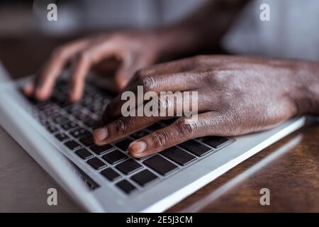 Ritagliato colpo di afro-americano digitando su laptop Foto Stock