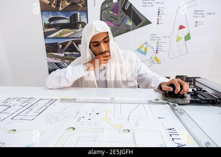 Architetto arabo che prepara la sua scrivania e pensa a nuove idee Foto Stock