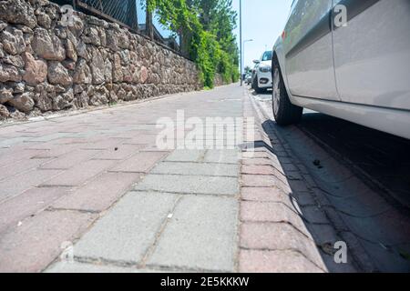 Marciapiede per i popoli in design moderno accanto ad alcune auto parcheggiate Foto Stock