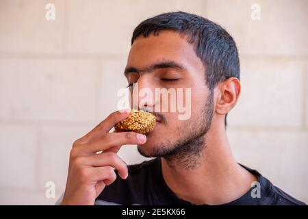 L'uomo musulmano sta mangiando falafel e godendo il suo tempo Foto Stock