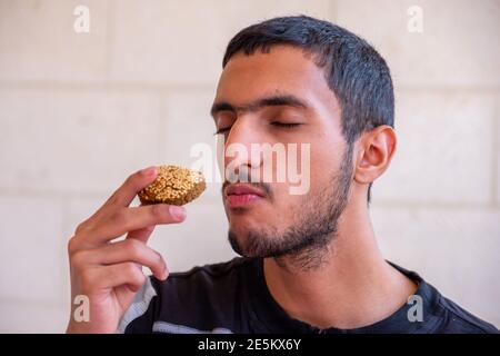 L'uomo musulmano sta mangiando falafel e godendo il suo tempo Foto Stock