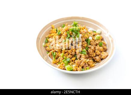 In un bel piatto rotondo, guarnire con cipolline, il maiale macinato e l'uovo fritti. Easy Asia cibo fatto in casa per bambini in Thailandia, immagine del cibo su bianco Foto Stock